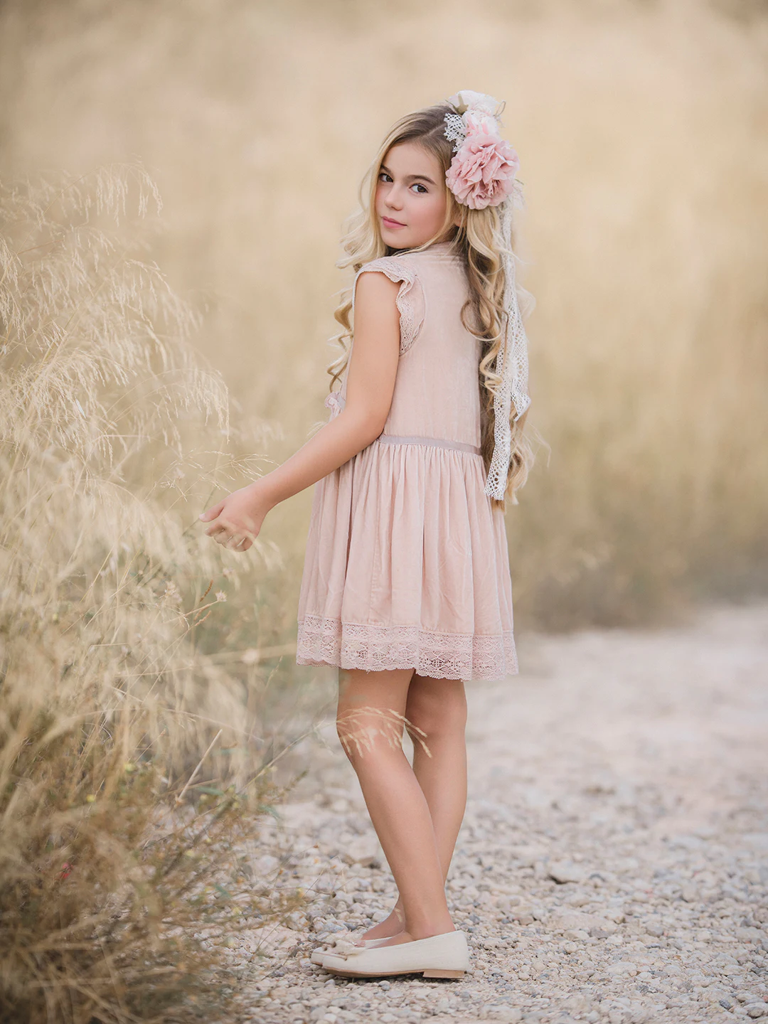 Niña con vestido rosa caminando en el campo