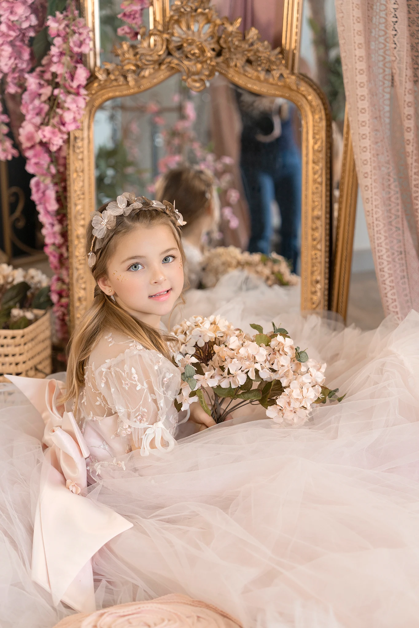 Retrato infantil con flores frente a un espejo dorado
