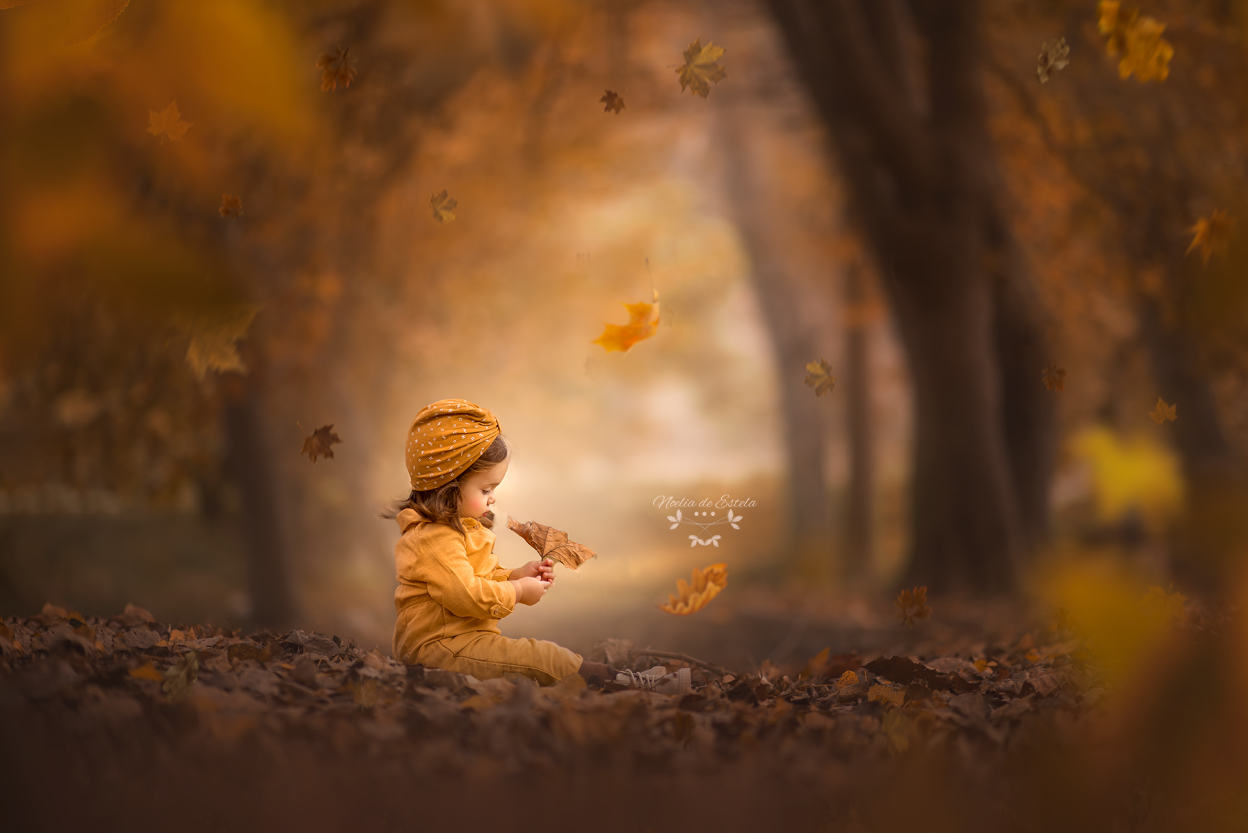 Niña descubriendo una hoja entre los tonos dorados del otoño